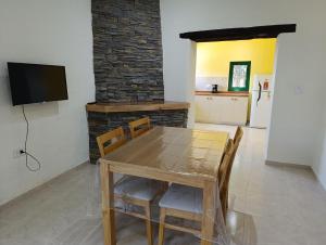 a dining room with a table and chairs and a television at Finca Magdalena Casa de Campo in San Rafael
