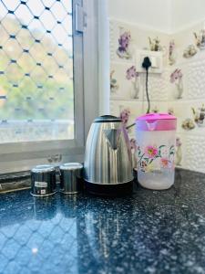 a coffee maker and containers sitting on a counter at Parvati home stay near by ramjhula,luxmanjhula in Rishīkesh