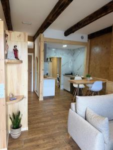 a living room with a couch and a kitchen at A Taberniña in O Pedrouzo