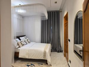 a bedroom with a bed with white sheets and pillows at Bwera-Comfortable Homes in Kasese