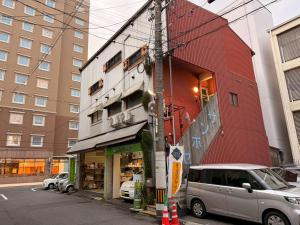 a building on a street with cars parked in front at ura San Jose in Okayama