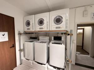 a kitchen with four washers and dryers on a shelf at ura San Jose in Okayama