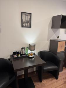 a table and two chairs in a room at Pension Ksenija Hanau in Hanau am Main +7 photos