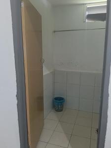 a bathroom with a shower and a blue bucket at Mulu D Cave Homestay Room 2 in Mulu +12 photos