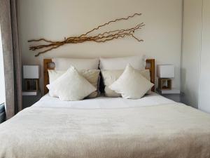a bed with white sheets and white pillows at Gîte Les Lauriers Roses in Marseillan +33 photos