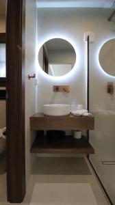 a bathroom with a sink and a mirror at Ianos Living Spaces - 02 in Korinthos +17 photos
