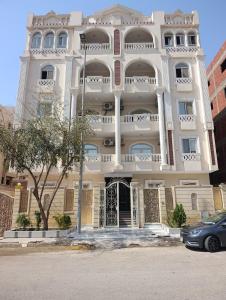 a large white building with a car parked in front of it at Tamaya Hotel, Fifth Settlement, New Cairo in Cairo