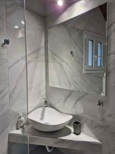 a white bathroom with a sink and a mirror at Baso Hilltop Apartments in Argassi +45 photos