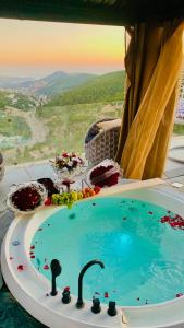 a bath tub in a room with a view at Grape Resort منتجع وشاليهات عنب in Ajloun