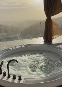a bath tub with a faucet in a room at Grape Resort منتجع وشاليهات عنب in Ajloun