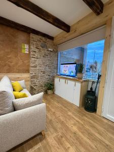 a living room with a couch and a flat screen tv at A Taberniña in O Pedrouzo