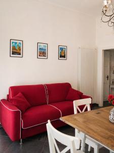 a red couch in a living room with a table at Royal Nest Venaria Reale in Venaria Reale