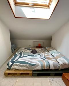 a bedroom with a bed with a skylight at Orizzonte guest house in Laigueglia
