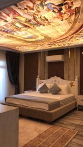 ein Schlafzimmer mit einem großen Bett mit einem Gemälde an der Decke in der Unterkunft Apera garden in Bulgurca + 16 Fotos