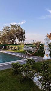 Eine Hängematte und eine Statue neben einem Pool in der Unterkunft Apera garden in Bulgurca