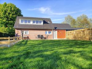 a house with a fence and a yard at Bargerveenhuis in Weiteveen