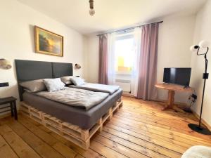 a bedroom with a bed and a television in it at Apartament Świętojański in Tolkmicko