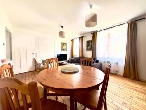 a living room with a table and chairs and a couch at Apartament Świętojański in Tolkmicko