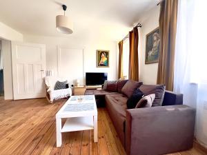 a living room with a couch and a table at Apartament Świętojański in Tolkmicko +8 photos