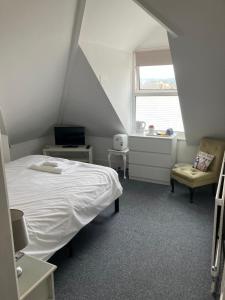 a small bedroom with a bed and a window at Seaview Sanctuary in Eastbourne
