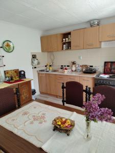a kitchen with a table with a bowl of fruit on it at Seosko domacinstvo Gardic in Užice