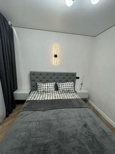 a bedroom with a bed and a light on the wall at ЖК Акварель 8 in Odesa