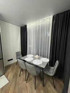 a dining room with a table and chairs and a window at ЖК Акварель 8 in Odesa +6 photos