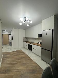 a large kitchen with white cabinets and a refrigerator at ЖК Акварель 8 in Odesa