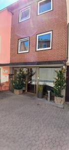 a brick building with potted plants in front of it at Hotel Birnbaum in Ansbach