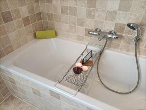 a bath tub with a shower and a basket on it at Bargerveenhuis in Weiteveen +40 photos