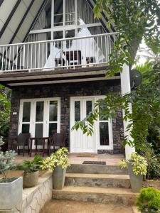 a house with a balcony and stairs leading up to it at Doranagala Holiday Cabin in Rattota
