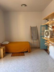 a bedroom with a bed with an orange blanket and a microwave at Sol, Terra e Mar- No coração do Plateau in Praia