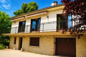 a brick house with a balcony on top of it at Maison 10 personnes 4 chambre 2 sdb in Liourdres