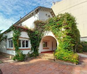 a white house with an archway in front of it at Bon Repòs in Cambrils