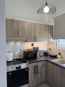 a kitchen with wooden cabinets and a stove top oven at Urban Nest Corinth in Korinthos