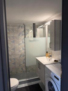 a bathroom with a toilet and a sink and a washing machine at Urban Nest Corinth in Korinthos +7 photos