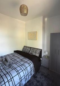 a bedroom with a black and white bed and a cabinet at Central 2 Bed House in Huddersfield