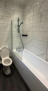 a bathroom with a toilet and a shower and a tub at Central 2 Bed House in Huddersfield