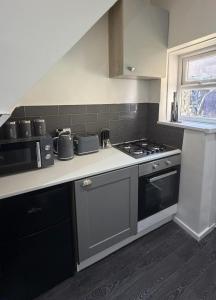 a kitchen with a stove and a counter top at Central 2 Bed House in Huddersfield
