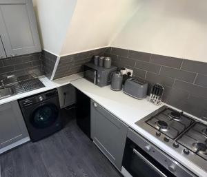 a kitchen with a stove and a washing machine at Central 2 Bed House in Huddersfield +5 photos