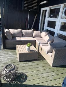a couch and a table on a patio at Feriehus Kornblomst in Tversted +9 photos