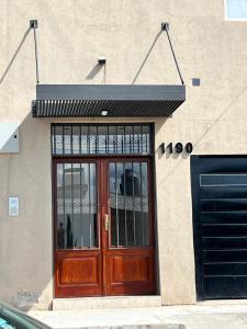 a building with a wooden door on the side of it at Alojamiento Guemes II in San Fernando del Valle de Catamarca