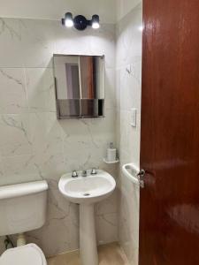 a bathroom with a sink and a toilet and a mirror at Alojamiento Guemes II in San Fernando del Valle de Catamarca +8 photos