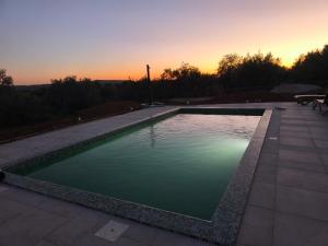a swimming pool with a sunset in the background at Casa Da Liberdade in Alte