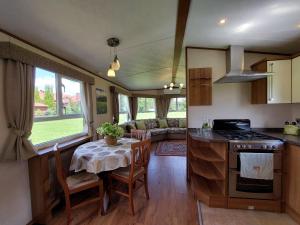 a kitchen and dining room with a table in a caravan at Agroturystyka Bobrowa Chata in Iława