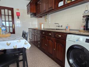 a kitchen with a sink and a washing machine at JB House in Peniche