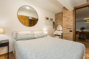 a bedroom with a bed and a mirror on the wall at La Pedica B&B in Grottaferrata