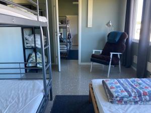 a dorm room with bunk beds and a chair at Tängerdalens camping och café in Övertänger