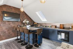 a kitchen with a bar with stools at Cannons Loft Central Buxton, Duplex loft 3 bedroom Set over 3 floors stairs no lift sleeps 5 in Buxton