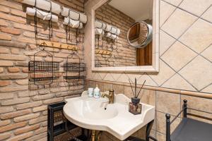 a bathroom with a sink and a brick wall at La Pedica B&B in Grottaferrata +28 photos